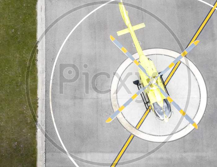 Top view yellow helicopter on helipad