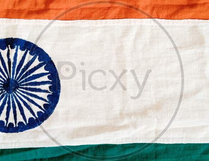 Indian flag showing Ahsoka chakra prominently, saffron and green colors partially visible with copyspace