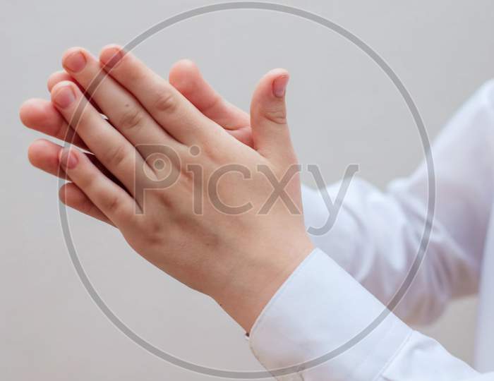 Two hands in a white shirt that are treated with alcohol sanitizers. Disinfection of the hands. Prevention of disease. Cleanliness is the key to health.
