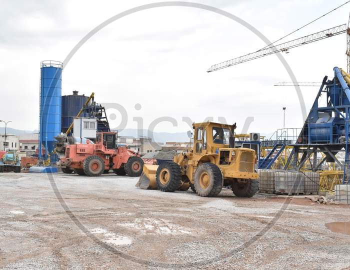 Construction site with caterpillar and silos