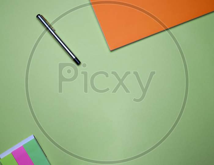 Business, Office, Student, Education Flat Lay, Table Top. Sticky Notes, Orange Notebook, Pen On Green Background