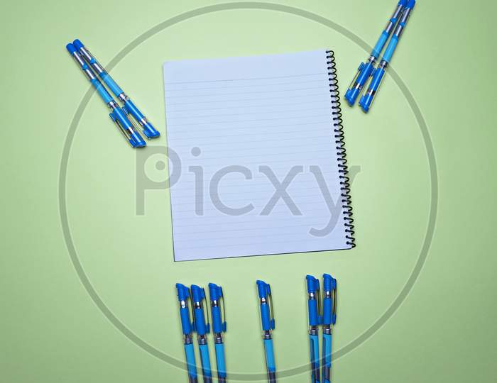 Business, Office, Student, Education Flat Lay, Table Top. Spiral Notepad And Pen On Green Background