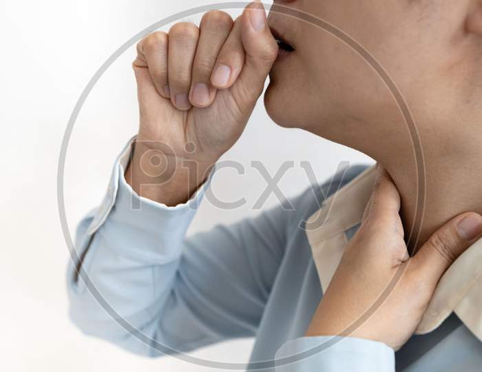 Sick asian woman with coughing into her fist and puts hand to her painful neck,sore throat,tonsillitis,symptom for cold,flu respiratory tract infection,painful swallowing,illness,health care concep