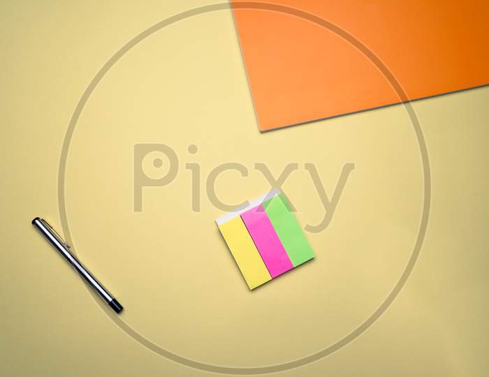 Business, Office, Student, Education Flat Lay, Table Top. Orange Notebook, Pen And Sticky Notes On Yellow Background