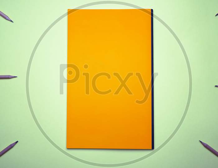 Business, Office, Student, Education Flat Lay, Table Top. Orange Notebook, Pencil On Green Background