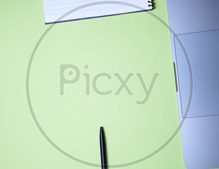 Business, Office, Student, Education Flat Lay, Table Top. Laptop, Spiral Notebook And Pen On Green Background