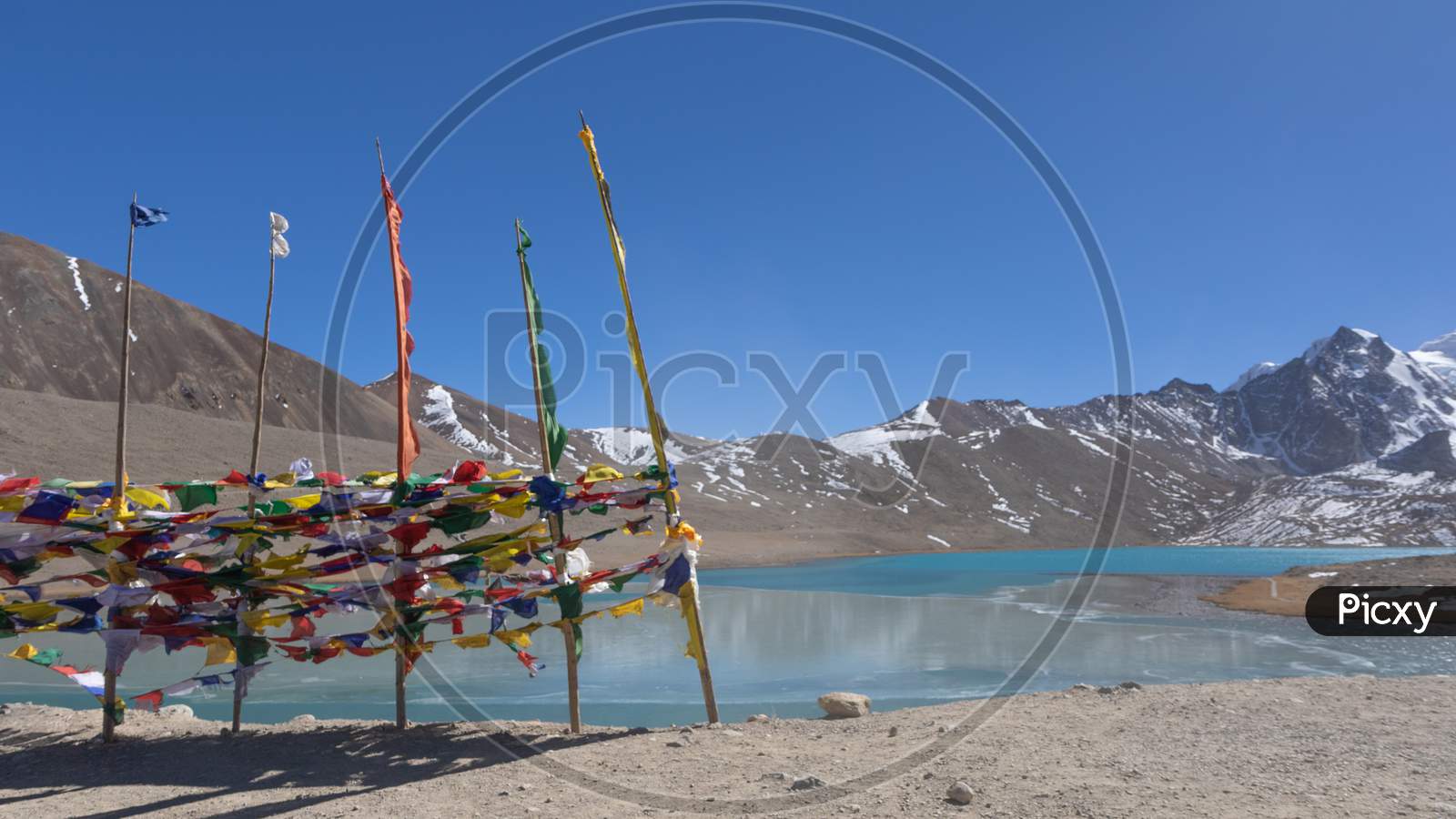 Gurudongmar Lake with Tibetan prayer flags in the foreground