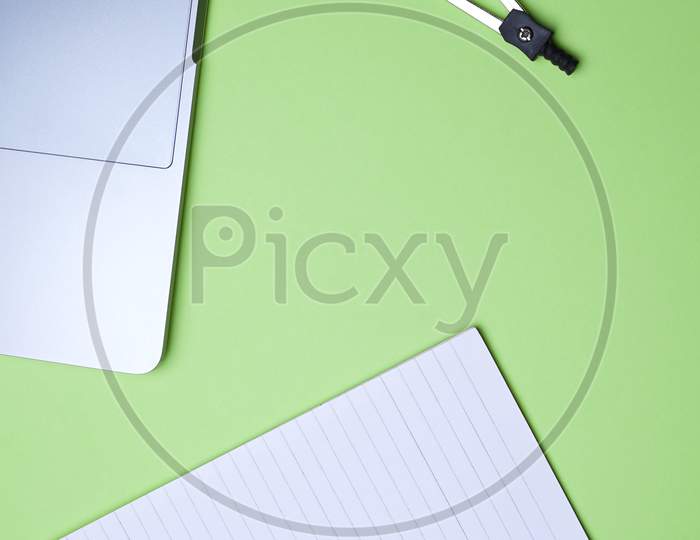 Business, Office, Student, Education Flat Lay, Table Top. Laptop, Compass, Spiral Notebook On Green Background