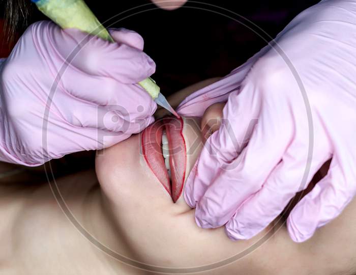 Carrying Out The Procedure Of Permanent Lip Make-Up For A Woman In A Tattoo Parlor