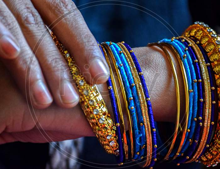 Stock Photo Of A Hand Of Indian Women Wearing Colorful Bangles With Gold Indian Design Bracelet, Picture Captured At The Time Of Indian Wedding Season