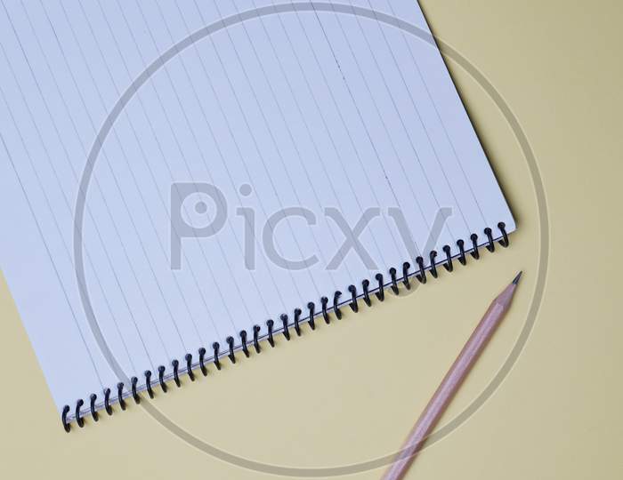 Business, Office, Student, Education Flat Lay, Table Top. Spiral Notebook, Pencil On Yellow Background