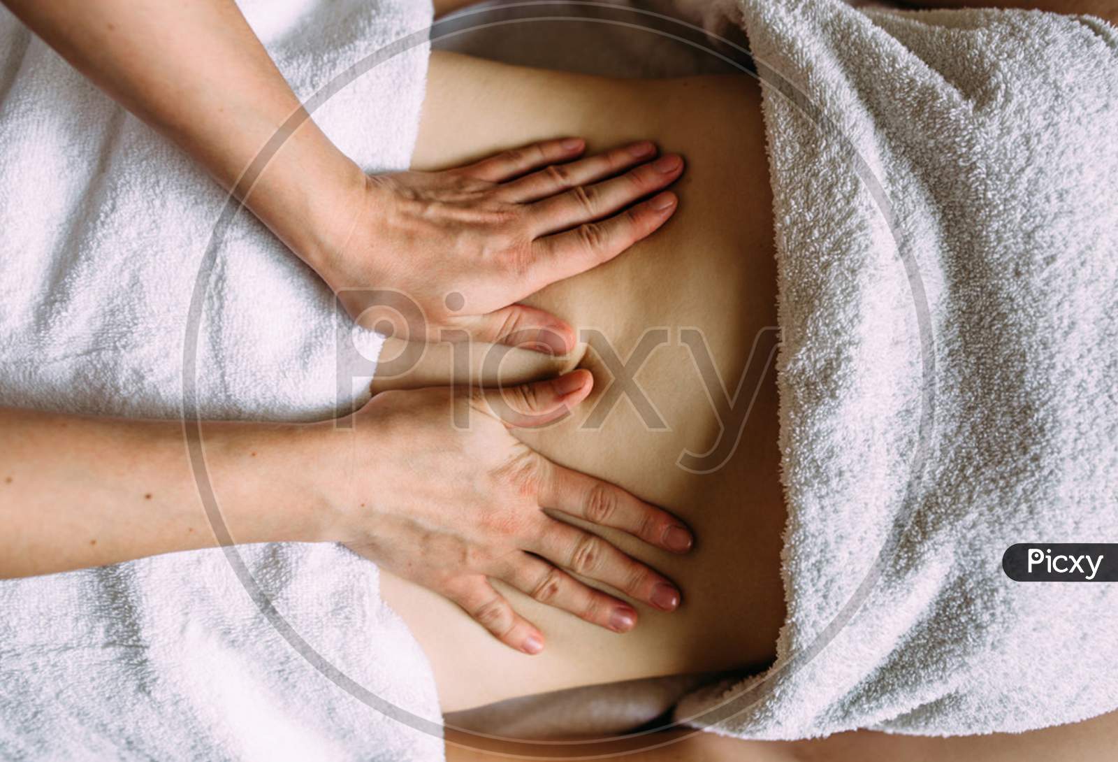 The Masseur Gives A Massage To The Female Belly At The Spa.