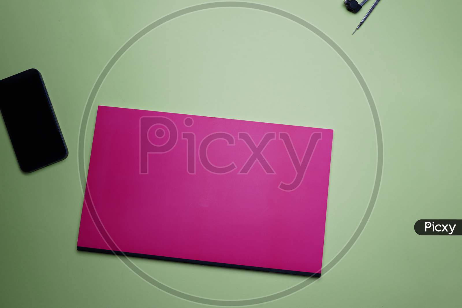 Business, Office, Student, Education Flat Lay, Table Top. Pink Notebook, Compass And Phone On Green Background