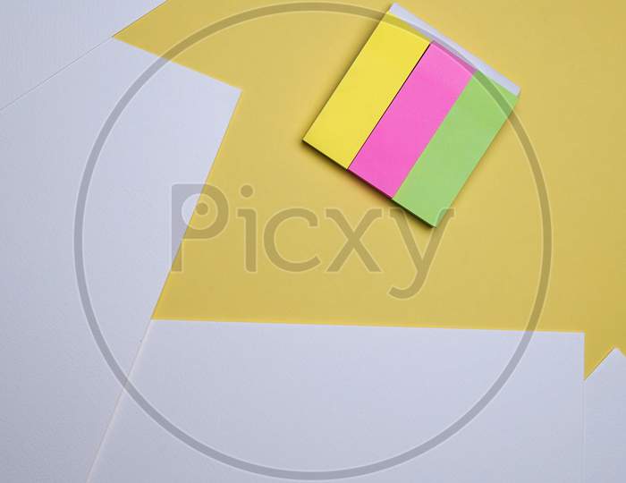 Creative Student, Homework Flat Lay, Table Top. White Sheets And Sticky Notes On Yellow Background