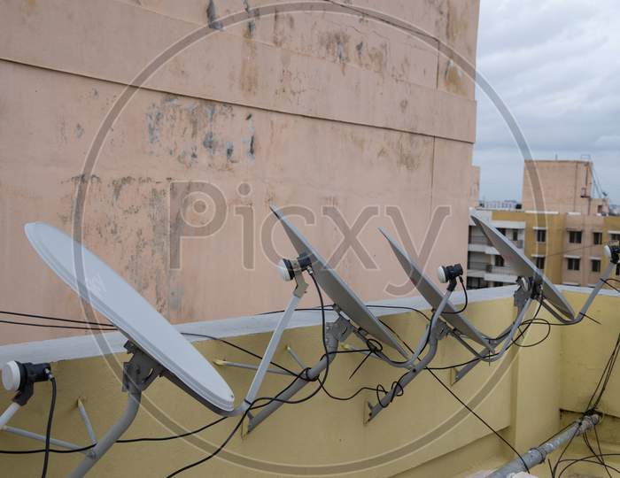View of dish antennas installed on roof top and pointing in one direction