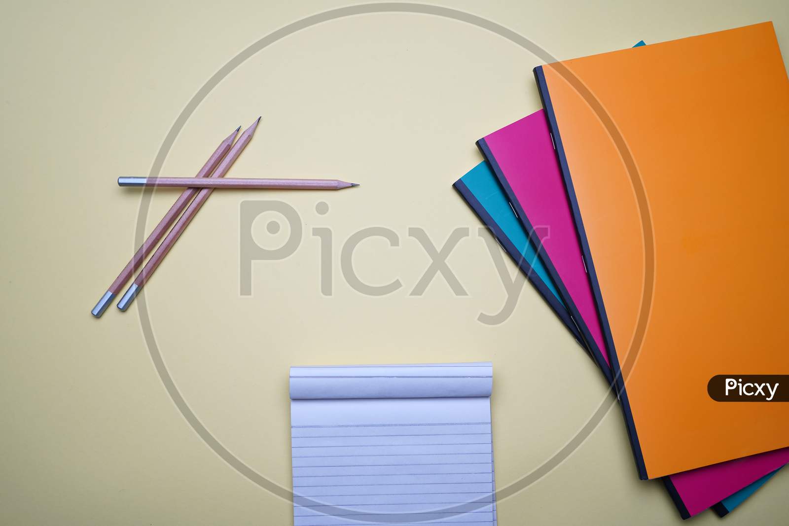 Business, Office, Student, Flat Lay. Cross Pencil, Notepad And Colorful Notebook On Yellow Background