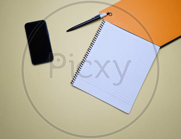 Creative Office, Business Professional Flat Lay, Table Top. Mobile, Phone, Spiral Notebook, Orange Notebook And Pen On Green Background