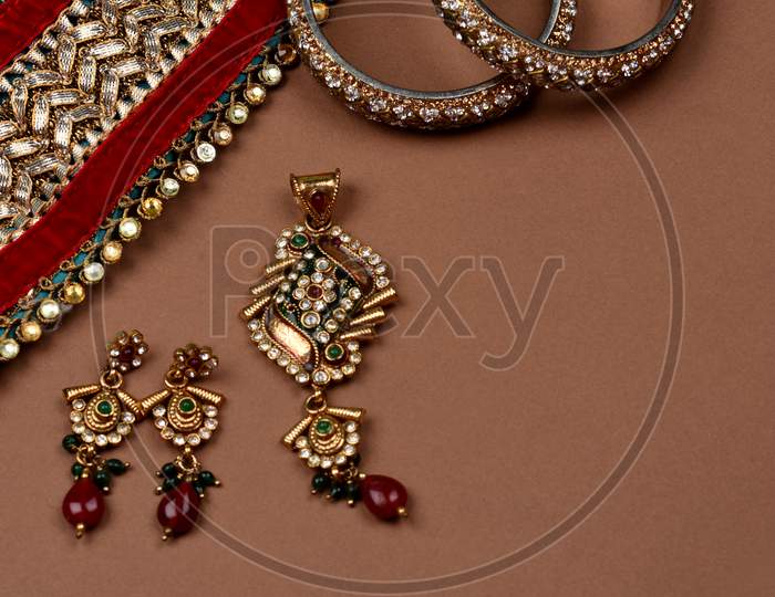 Antique Jewellery On A Brown Background, Golden Scarf, Gold Bracelet,Jewelry Background, Gold Necklace, Gold Earrings, Finger Ring.Style, Fashion And Design Of Jewelry. Indian Traditional Jewellery