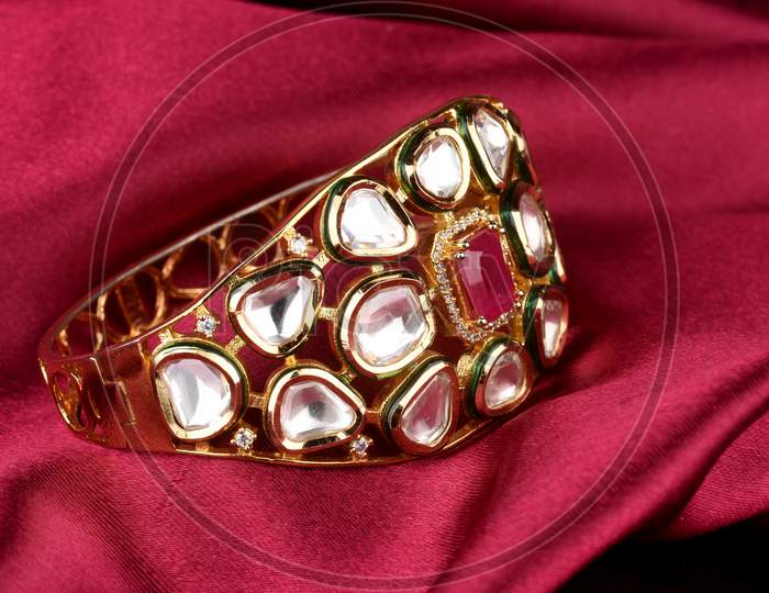Gold Bracelet On  A Red Satin Background. Kundan Bracelet,Style, Fashion And Design Of Jewelry. Indian Traditional Jewellery,Indian Wedding Jewellery