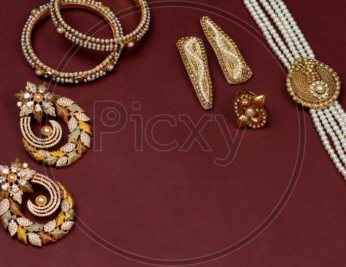Pearl Jewelry On A Red Background,Golden Jewellery, Pearl Bracelet,Pearl Hair Clip,Pearl Necklace Pearl Earrings,Finger Ring.Fashion And Design Of Jewelry. Indian Traditional Jewellery,Jewelry Bac