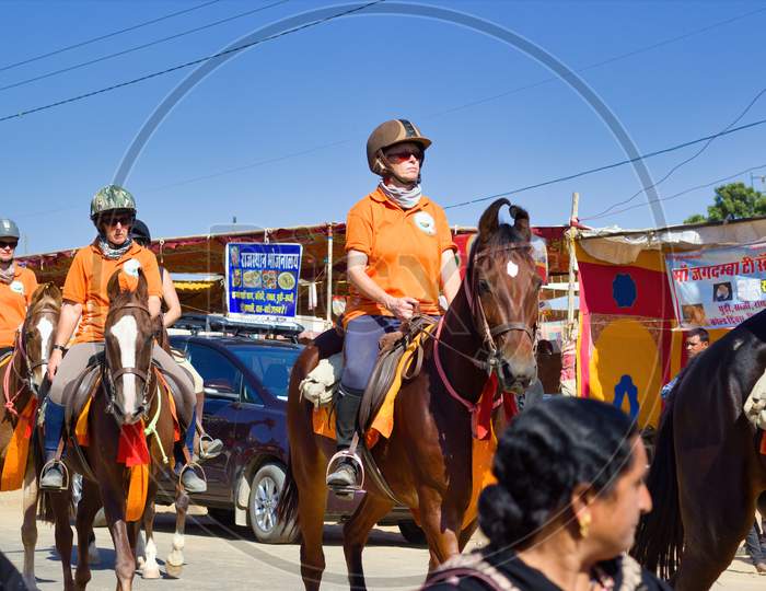 Pushkar, India - November 10, 2016: Foreigner Tourists Riding Horses With Helmet In The Biggest Fair Of Pushkar In The State Of Rajasthan