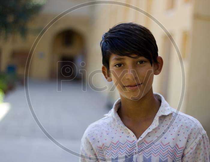 Pushkar, India - November 10, 2016: A Portrait Of A Young Indian Boy In The Street Of Rajasthan Looking At The Camera And Smiling While Working As A Guide In One Of The Tourist Attraction