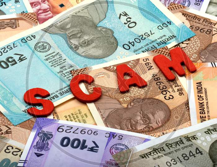 Scam And Money Concept,Scam Red Alphabets On Money Background,Indian Currency, Rupee, Indian Rupee,Indian Money, Business, Finance, Investment, Saving And Corruption Concept