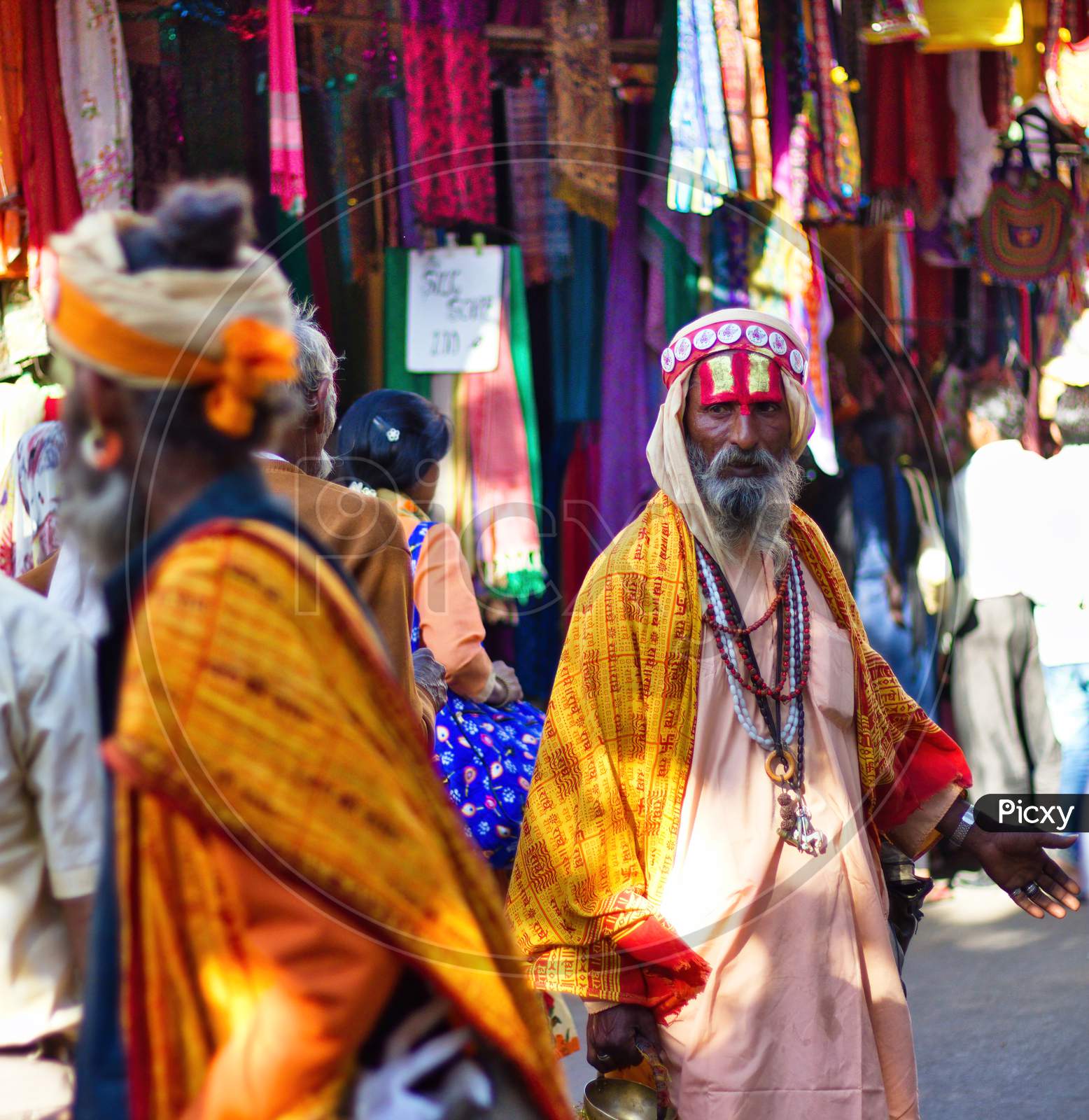 Pushkar, India - November 10, 2016: A Bearded Hindu Old Man With Vishnu Tilak On His Forehead And Orange Ethnic Wear Walking In Famous Pushkar Mela Or Fair In The State Of Rajasthan