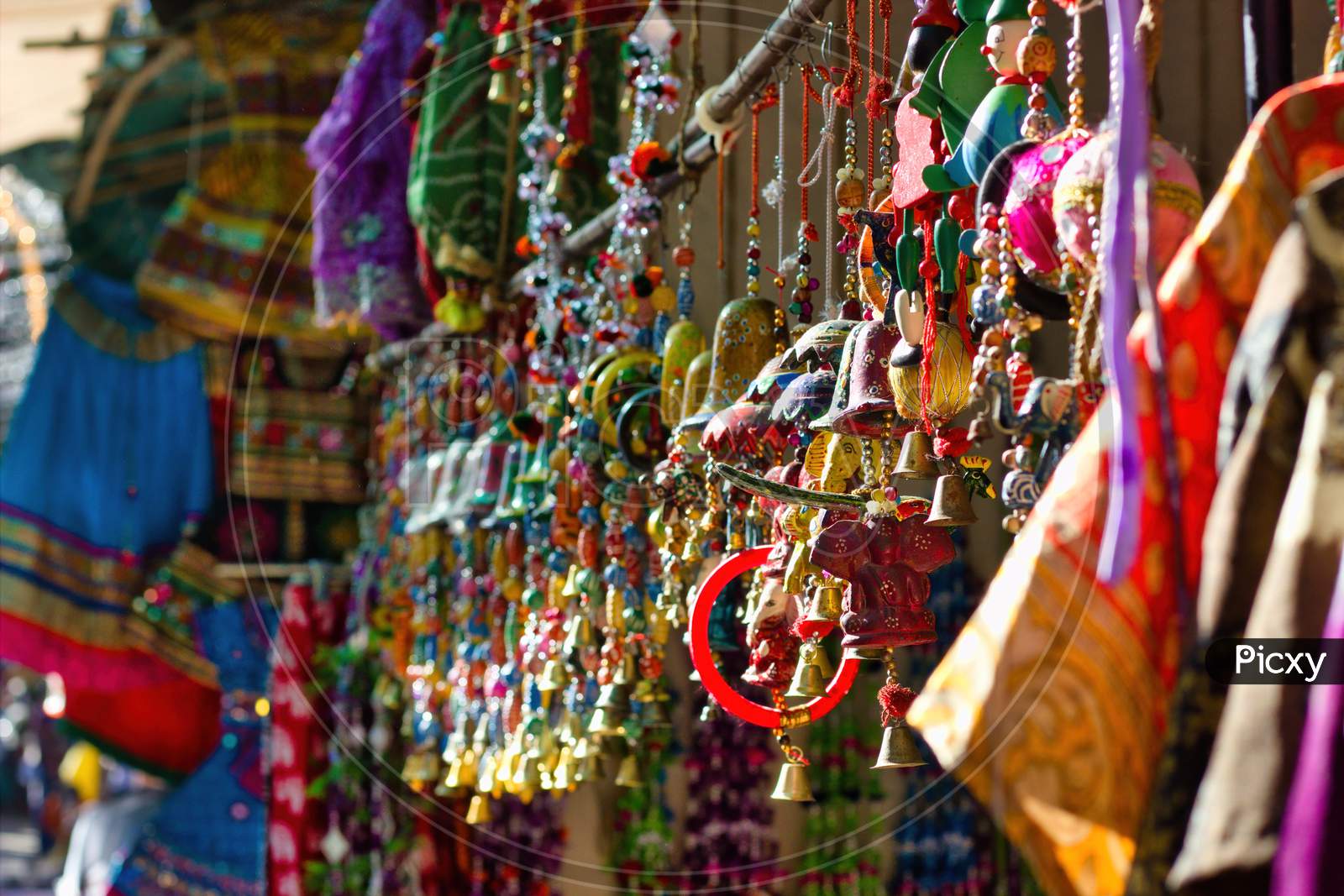 Bunch Of Colorful Decorative Item As Souvenir Being Hanging As Display For Sale In The Commercial Street Of Pushkar Fair In The State Of Rajasthan