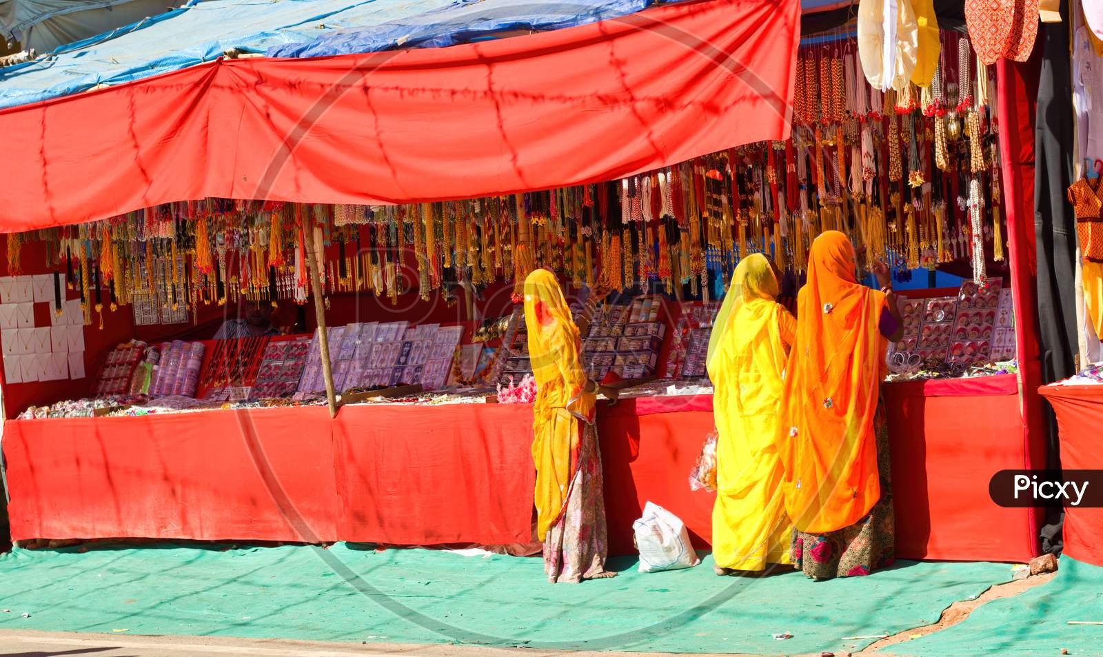 Pushkar, India - November 10, 2016: Bunch Of Women In Traditional Hindu Wear Saree Buying Or Shopping Jewelery Items In The Commercial Street Of Pushkar Fair In The State Of Rajasthan
