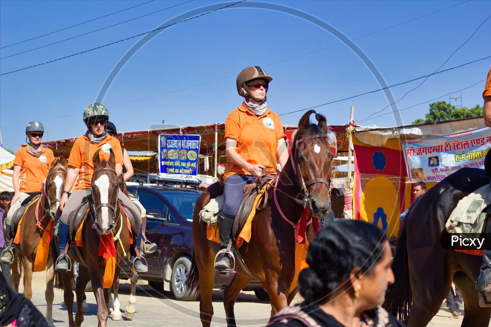 Pushkar, India - November 10, 2016: Foreigner Tourists Riding Horses With Helmet In The Biggest Fair Of Pushkar In The State Of Rajasthan
