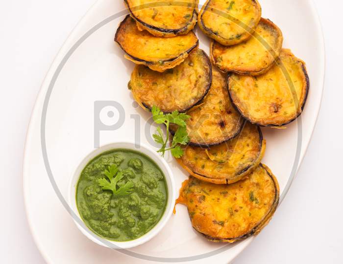 Tasty Brinjal Pakora Or Crispy Eggplant Fritters, Indian Tea Time Snack Served With Green Chutney
