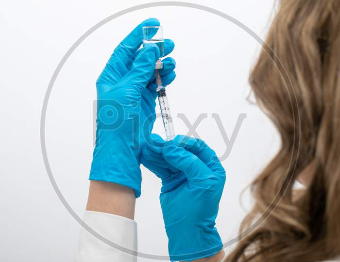 Doctor Scientis In Protective Gloves Holding Glass Vial With Injection Liquid. Vaccination Against Influenza And Coronavirus
