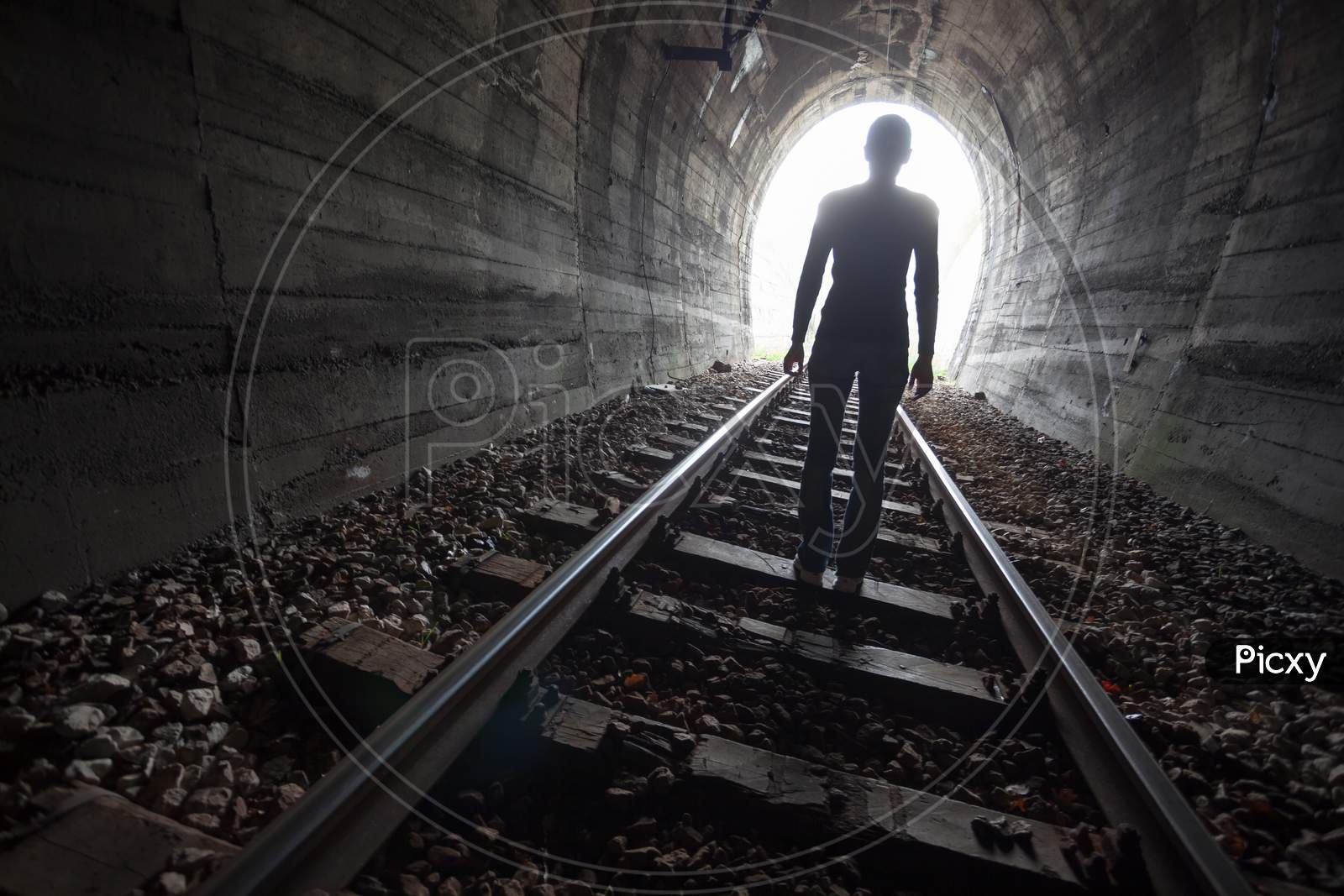 Man In A Tunnel Looking Towards The Light