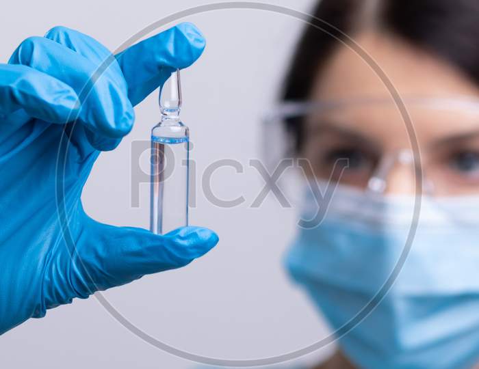 Doctor Scientist With Protective Gloves And Face Mask Holding Vaccine Medicine Dose