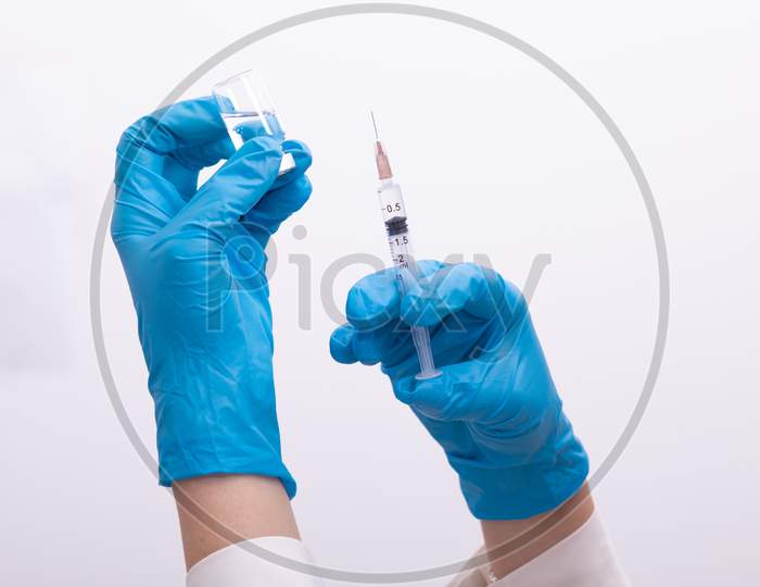 Doctor Scientis In Protective Gloves Holding Glass Vial With Injection Liquid. Vaccination Against Influenza And Coronavirus