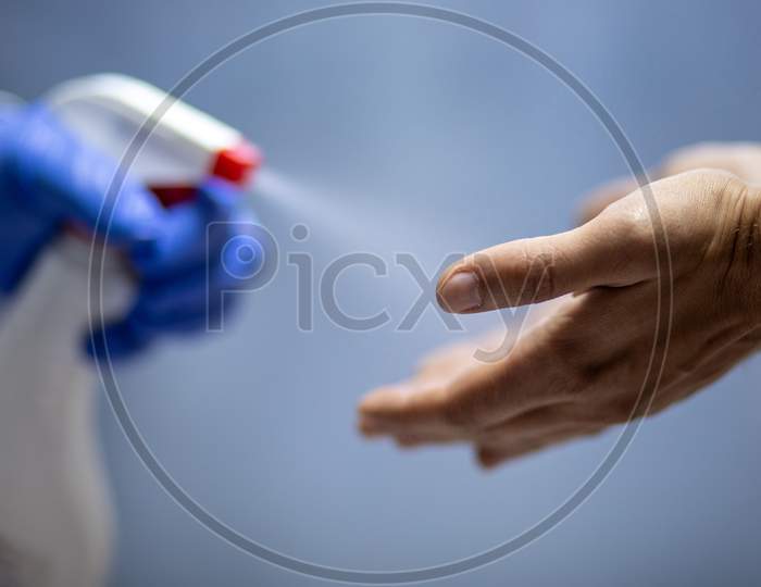 Spraying Hands With Antiseptic Solution