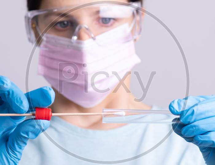 Doctor Holding Test Kit For Pcr Testing Virus Covid19. Coronavirus Covid-19 Swab Test Kit, Ppe Protective Mask And Gloves, Tube For Taking Op Np Patient Specimen Sample, Dna Rna Protocol Process
