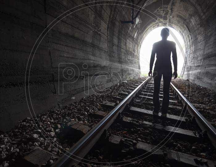 Man In A Tunnel Looking Towards The Light