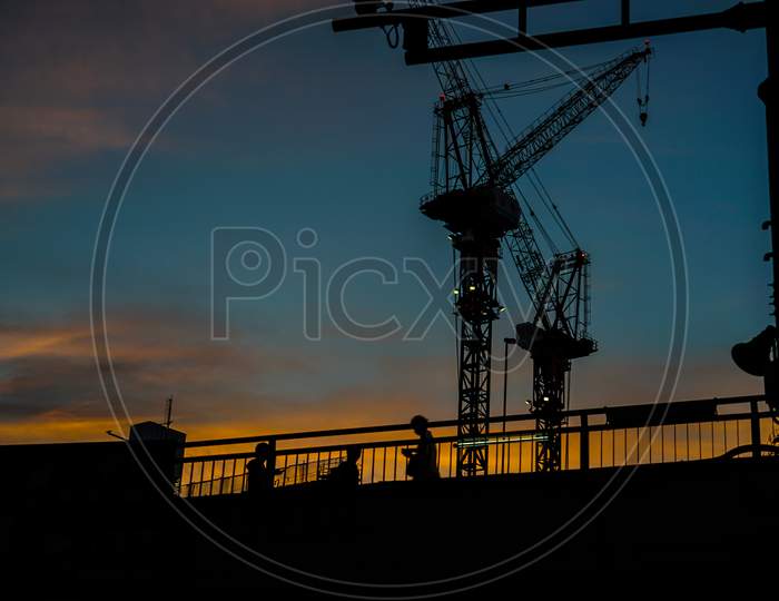 Sunset And A Crane And A Footbridge