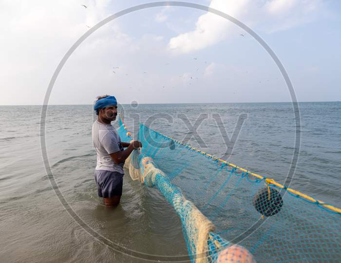 Chennai, Tamil Nadu, India - Rameswaram 19 01 2021: A Man With Turban Holding Fishing Net In Water