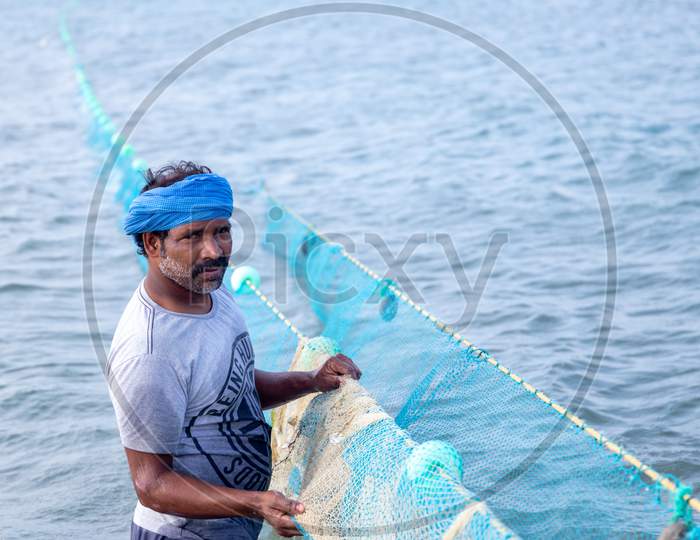 Chennai, Tamil Nadu, India - Rameswaram 19 01 2021: Photo Of Man Catching Fish With Fishing Nets