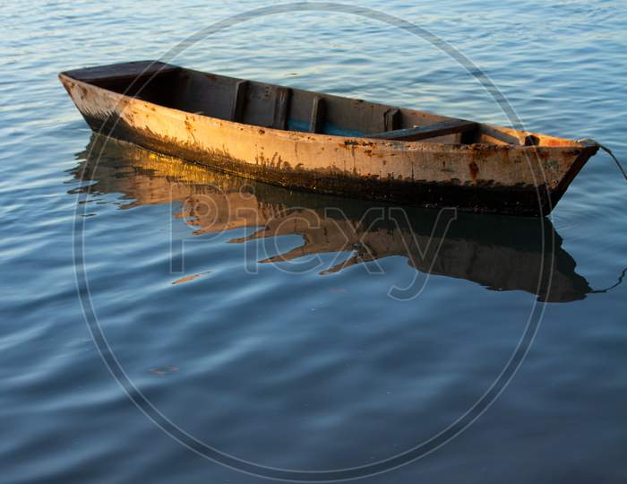 Small Wooden Fisherman Boat Or Transport Moored In The Harbor. Wooden Boat In Calm Water.