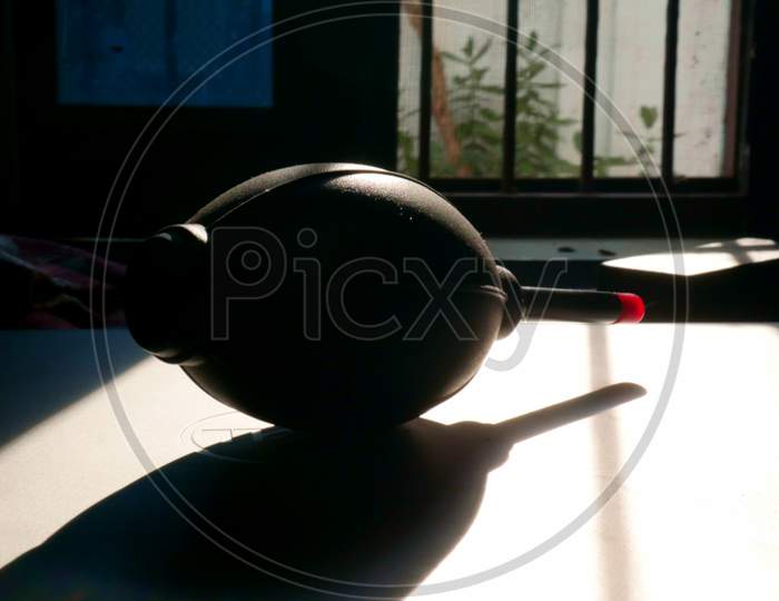 Camera Lens Blower Presented Near Window On Shadow Light For Technological Tools Cleaning Concept.