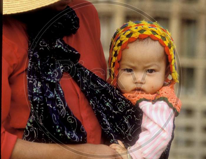 A Chinese Mother Holding Her Child In The Arms