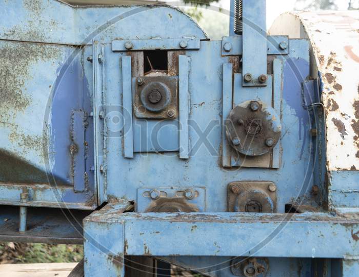 Old Rusted Machinery Painted In Blue Color Kept Under Sunglight.