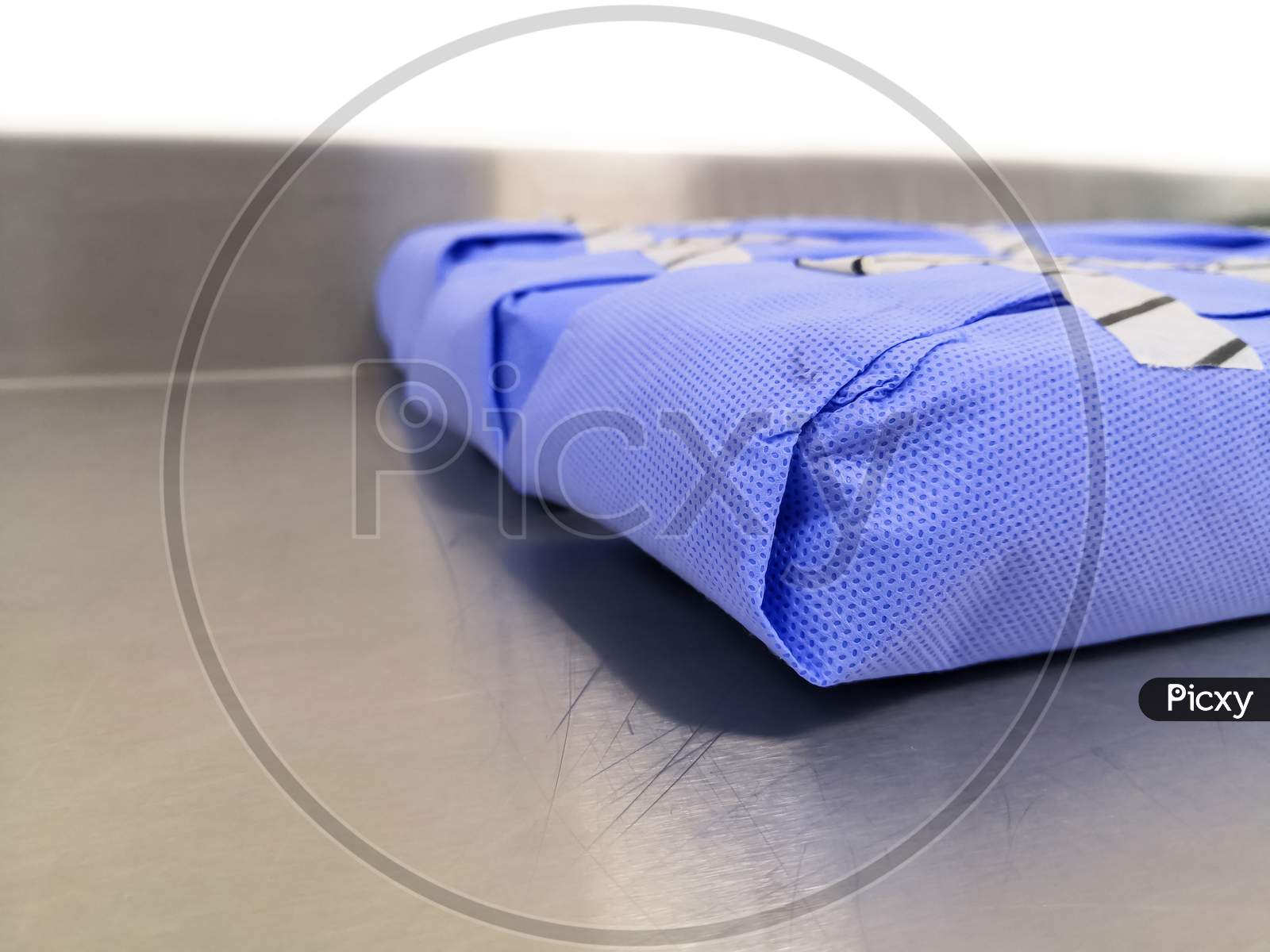 Side View Of Surgical Instruments Set Wrapped With Disposable Blue Drape Sheet