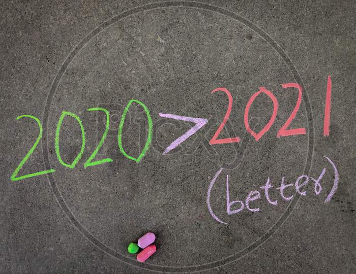 The Inscription Text On The Grey Board, 2020 Greater Than Symbol 2021 (2020 Better Than 2021) . Using Color Chalk Pieces.
