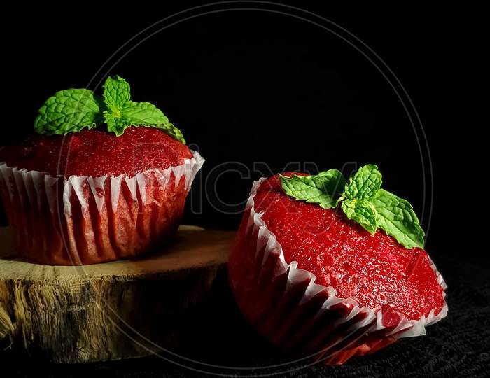 Closeup of Delicious Red Velvet cupcakes or muffins decorated with mint on top.
