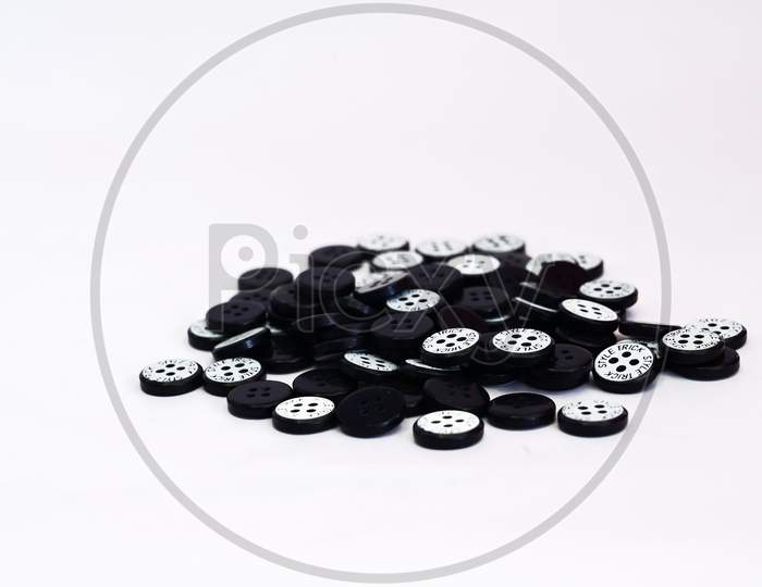 Simple Black Clothes Button On White Background With Copy Space.
